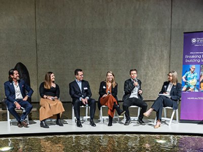 A panel of 6 people sitting at the front of a room