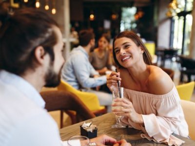 A man and a woman on a date, the woman holding a drink