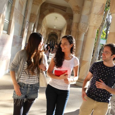 Photo of students in sandstone cloisters at UQ