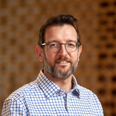 Phillip Vaughan head and shoulders in front of a brown background