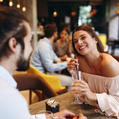 A man and a woman on a date, the woman holding a drink