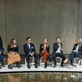 A panel of 6 people sitting at the front of a room