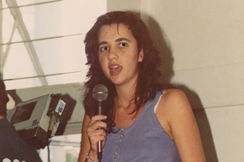 A woman standing onstage holding a microphone