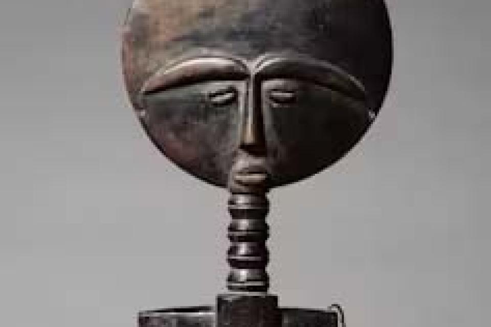 Wooden fertility doll with a cross-shaped body and flat, round head with eyebrows, eyes, nose and mouth