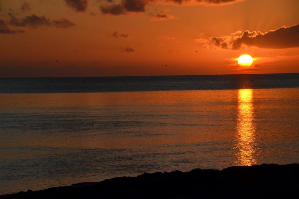 An orange sky at sunset over the water 