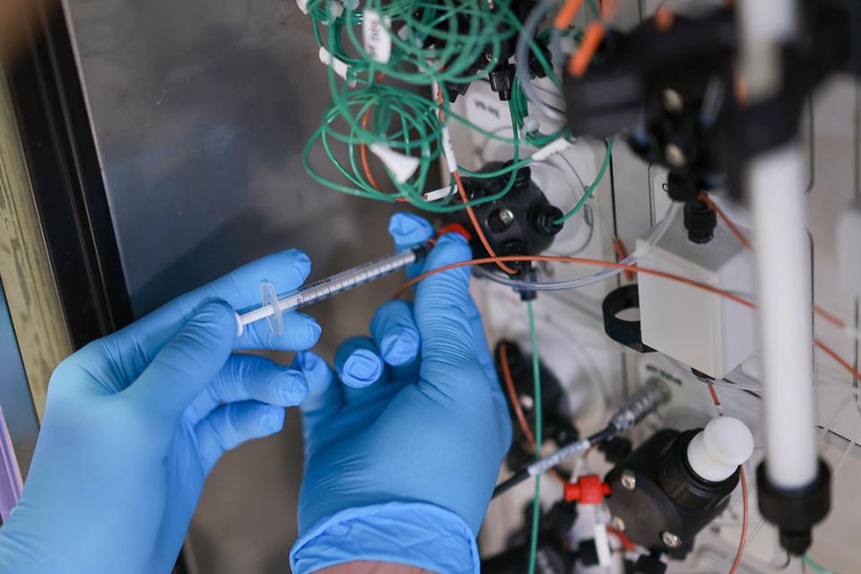 A pipette injecting into a electronic device surrounded by wires