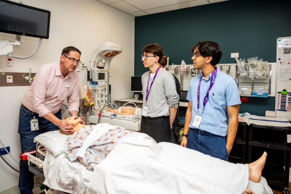 Dr Dan Halliday demonstrates patient care in Roma Hospital's simulation room with first-year medical students Jeremy Petsetas and Anmol Shuklar. 