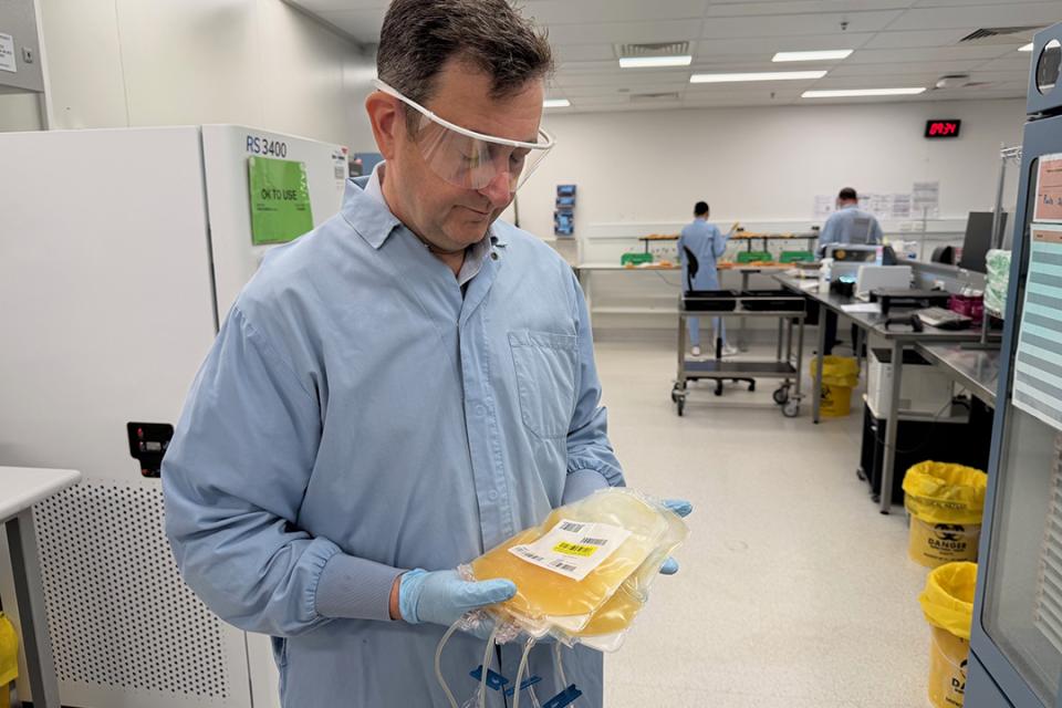 Professor Michael Reade holding up a bag of blood platelets