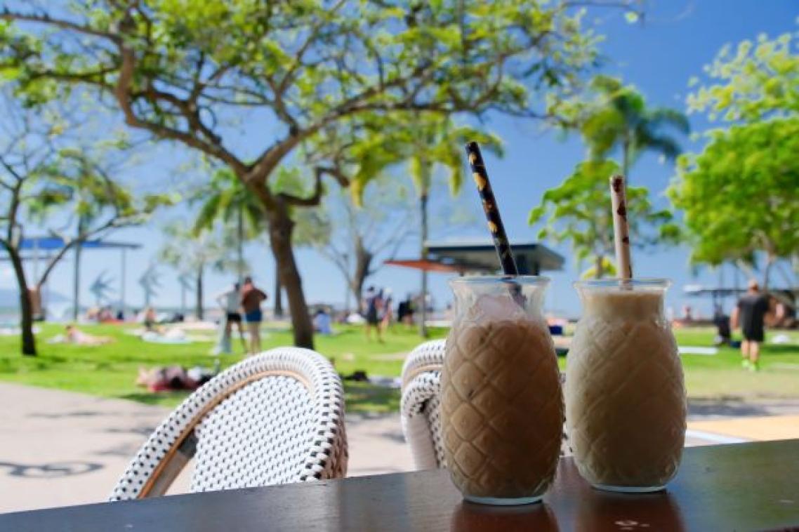 Two cocktails on an outdoor table at a tropical resort.
