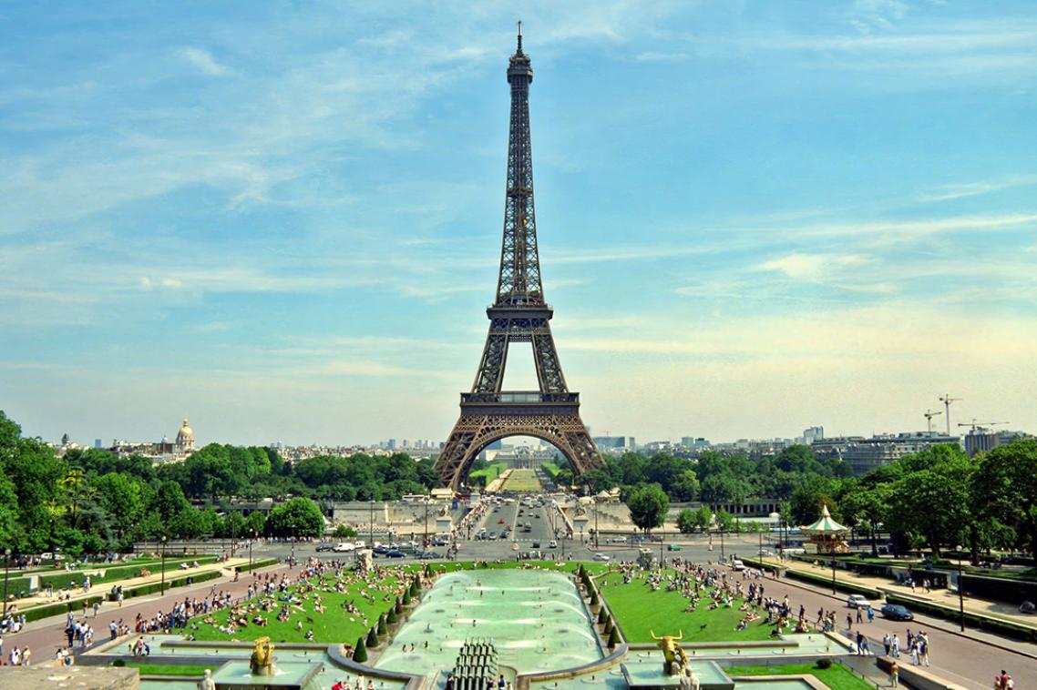 An aerial daytime photo of the Paris skyline including the Eiffel Tower.