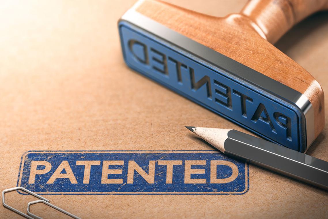 A blue stamp with the word 'Patented' stamped on a brown folder.