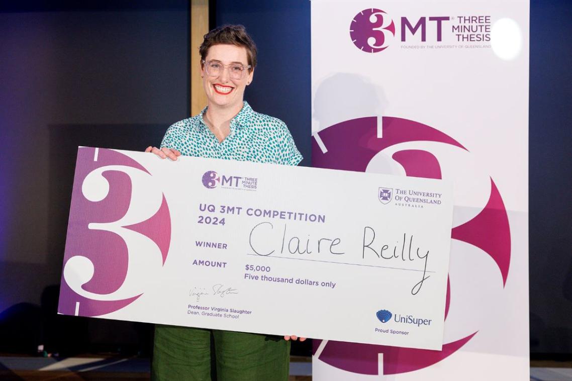 A woman holding a large check with the words 3MT printed in purplee