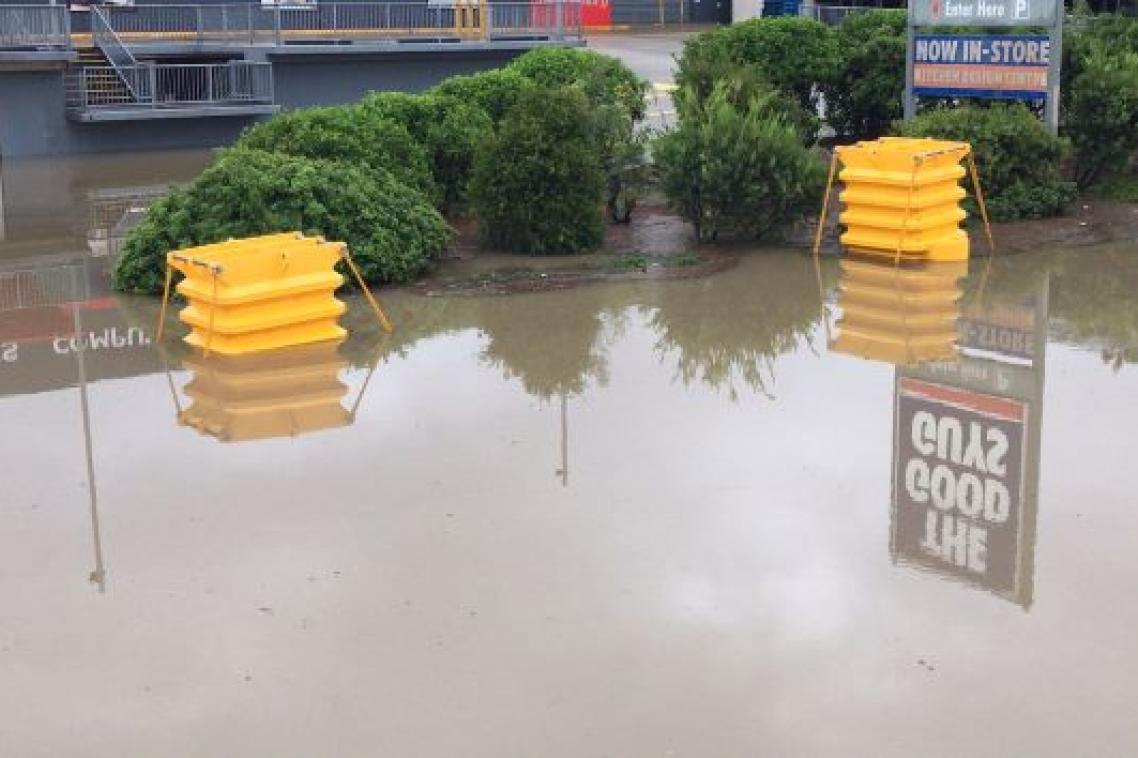 Brown flood water with 2 yellow plastic boxes.