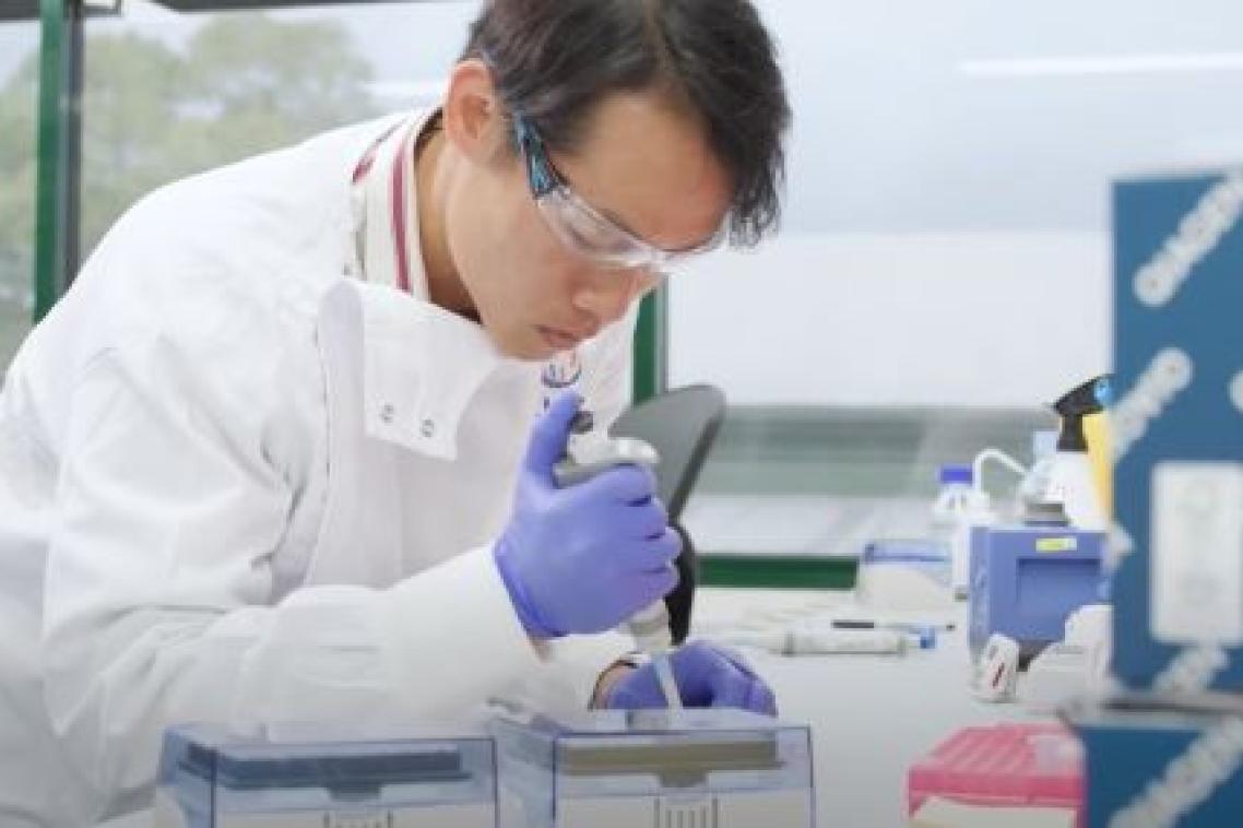 A man in a lab coat with a pipette