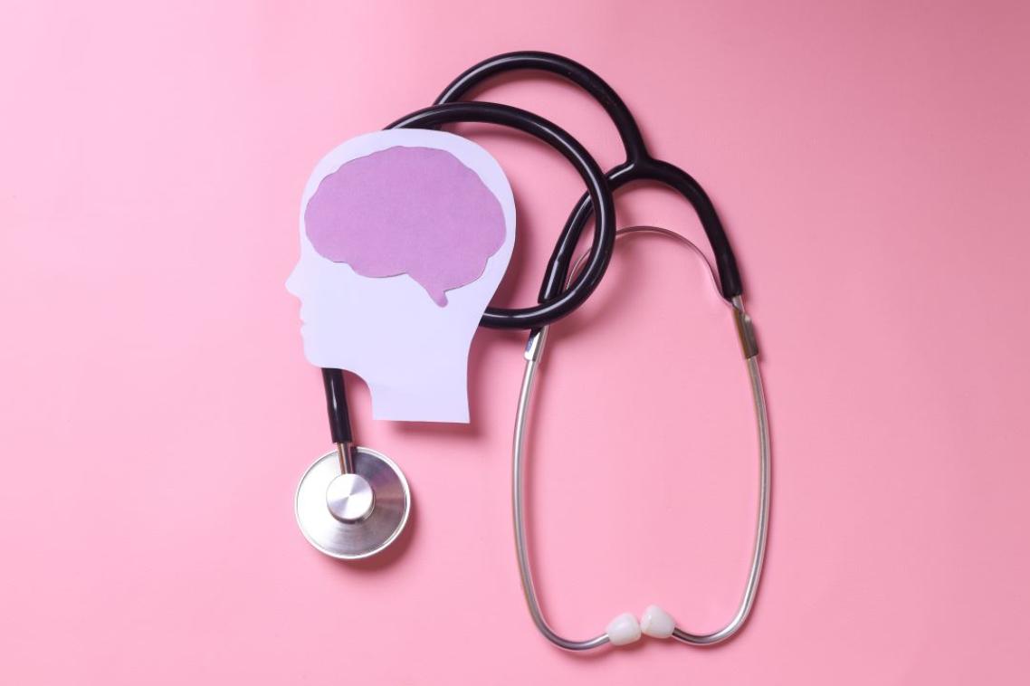 A stethoscope and a stylised human head and brain on a pink background.