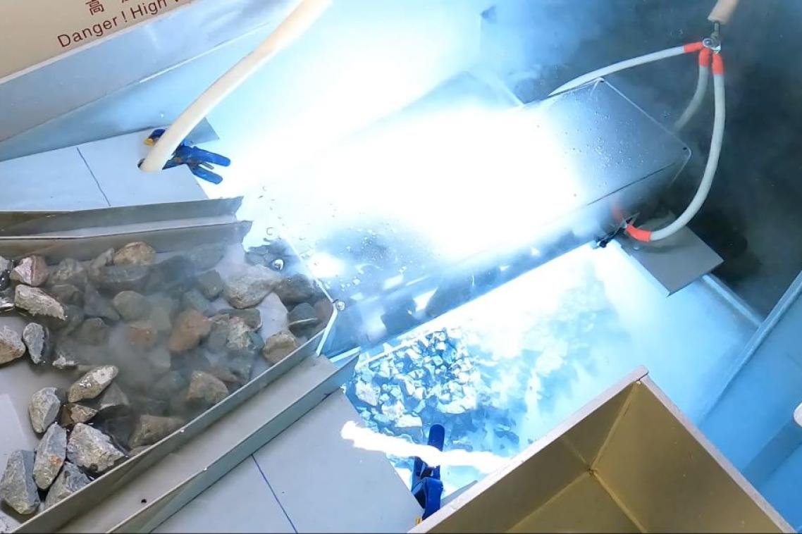 Rocks going down a funnel towards a bright light.