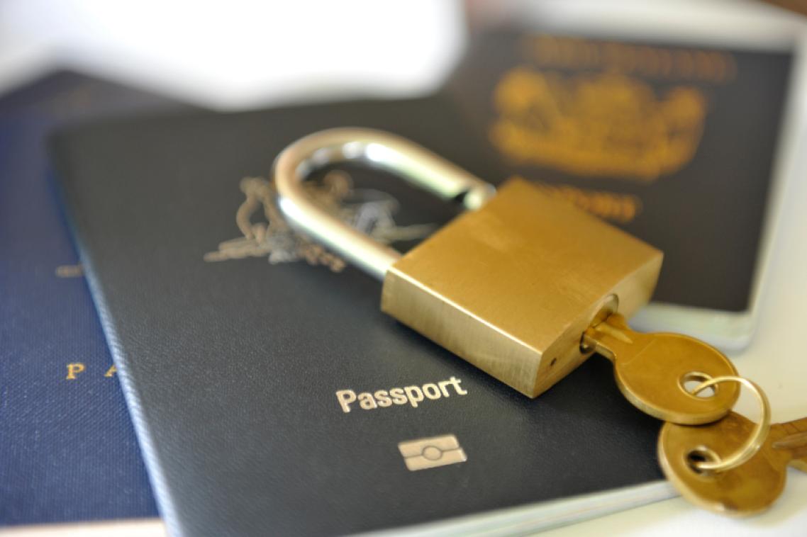 A gold lock on top of a passport.