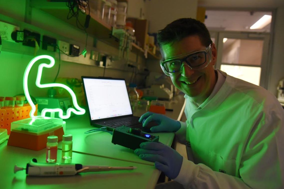 A researcher in a darkened lab with fluometric light.