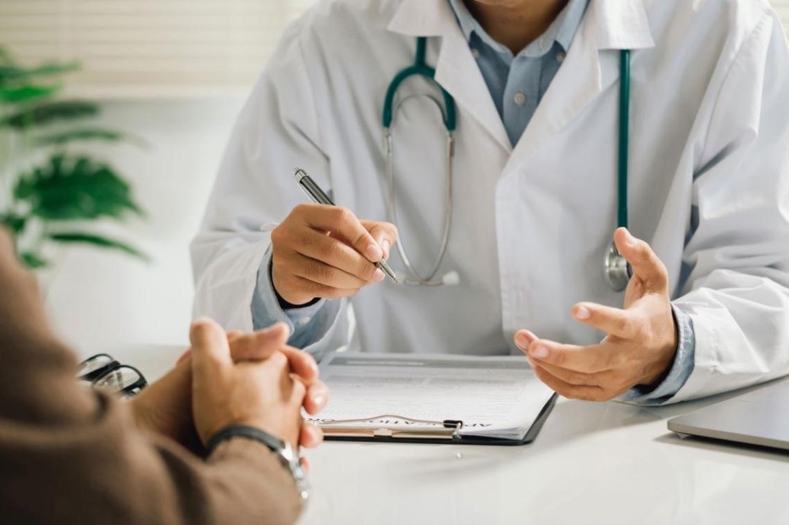 A doctor sits opposite his patient in a clinic