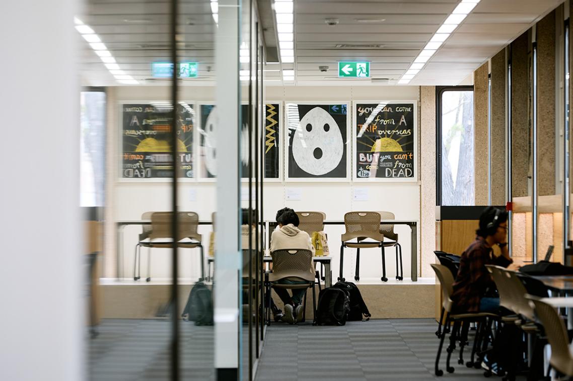 A series of artworks on display on a wall behind a desk