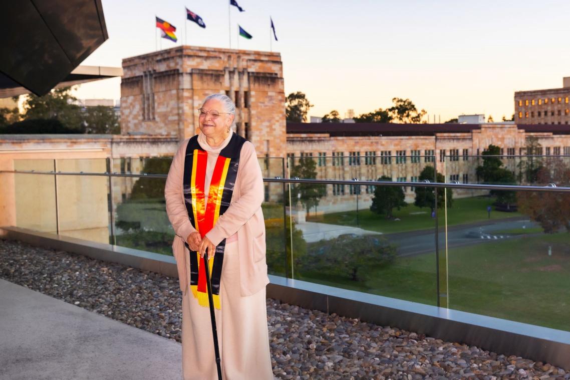 Aunty Jacqueline Kina standing in front of a sandstone building. 