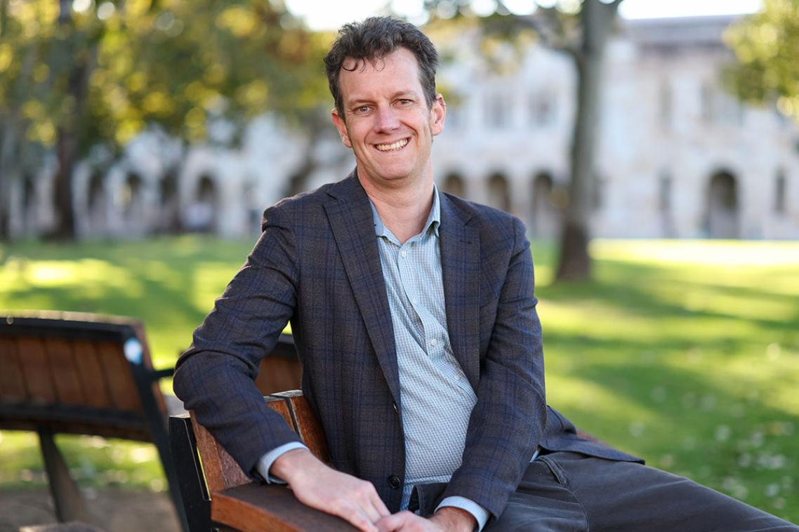 A man in a suit smiling at the camera