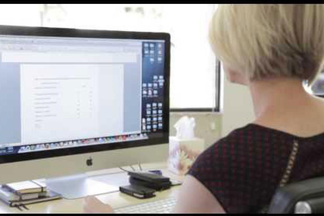 A woman looks at a computer screen