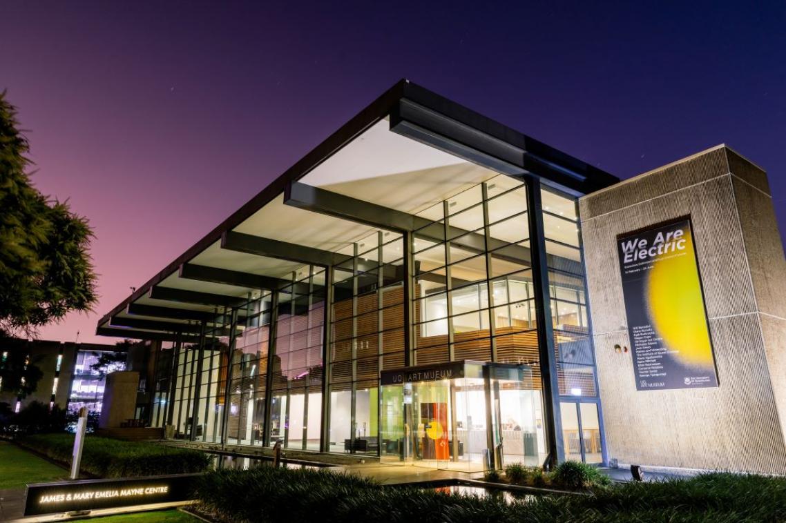 A large glass building at dusk, lit from within
