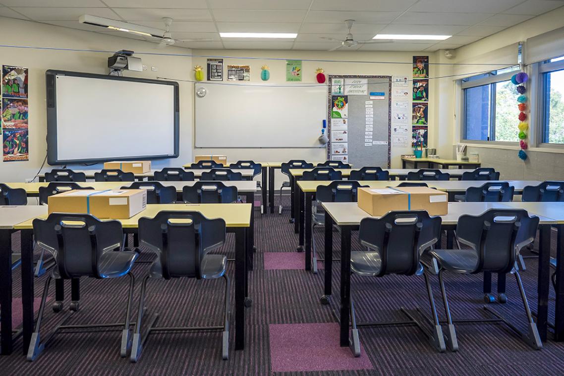 An empty classroom, as seen looking toward the whiteboard.