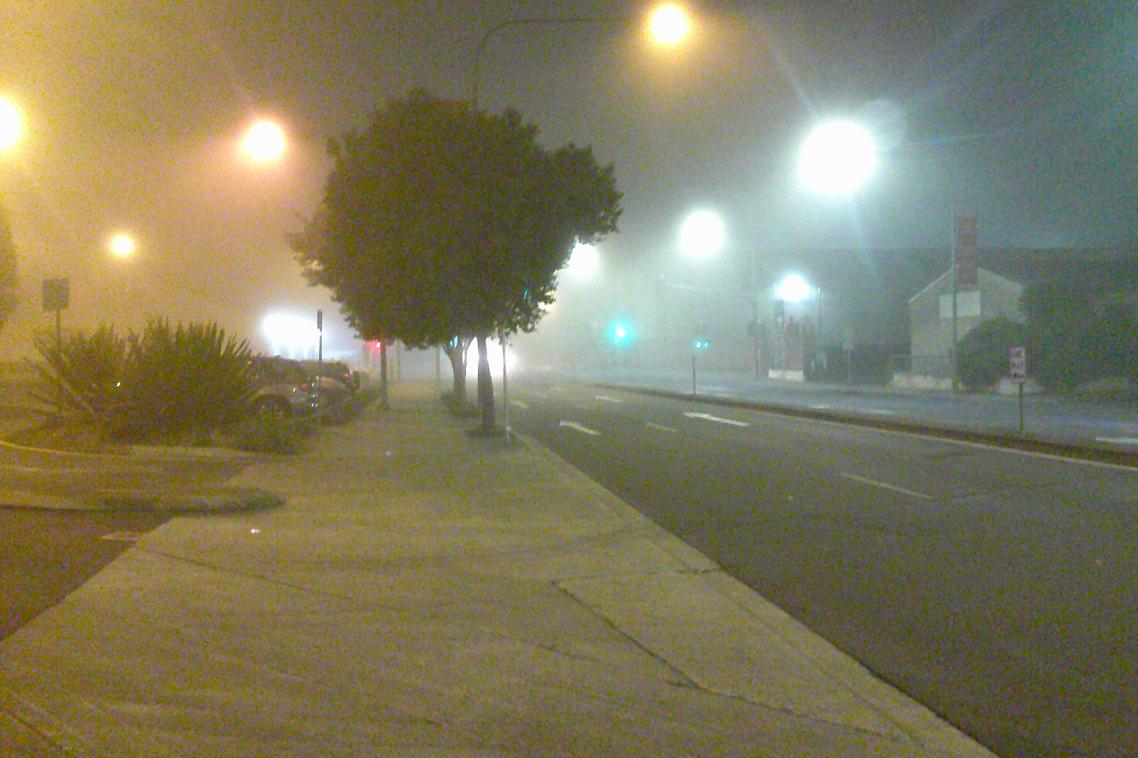 A foggy street in the dark.
