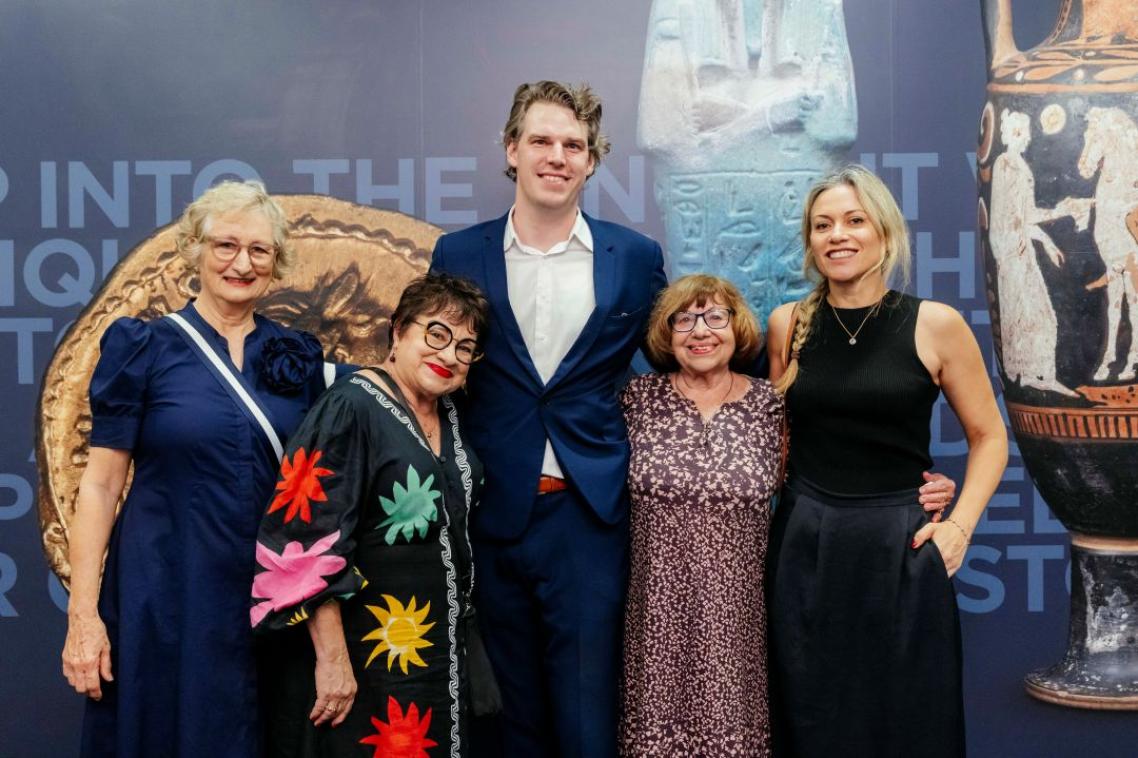 A group of people standing in front of a large poster