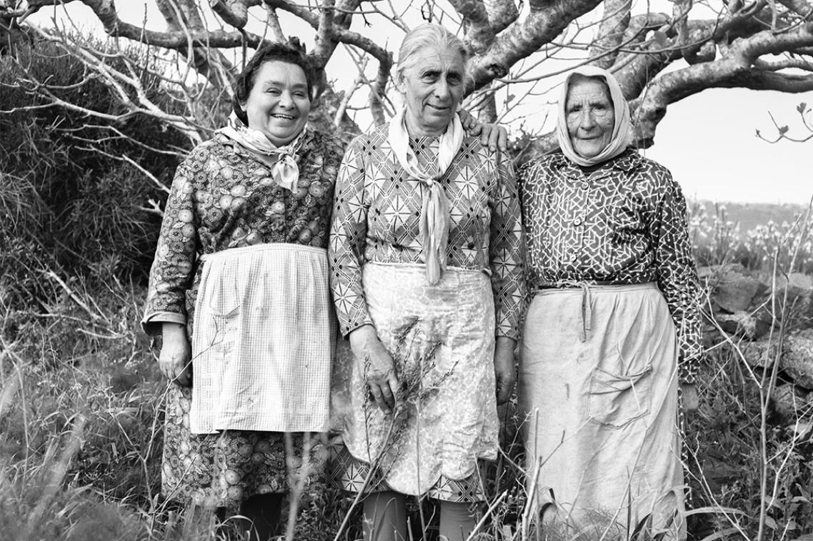 Three elderly women standing in a row