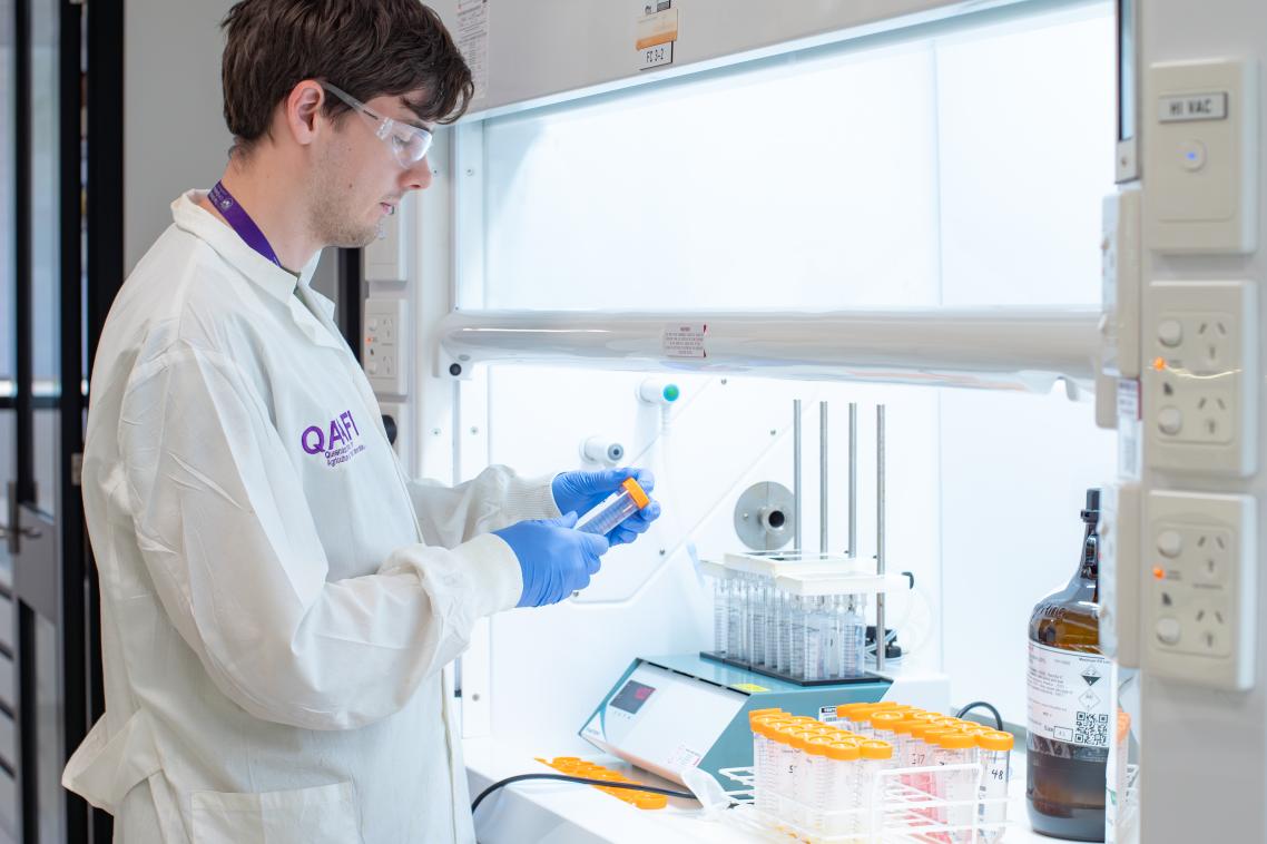 A man standing in a laboratory wearing a white coat.