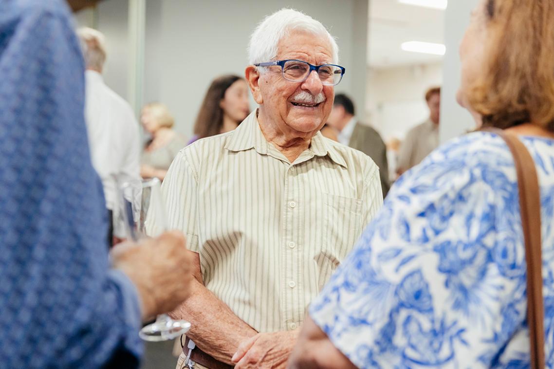 A man with a moustache at the opening night of the exhibition.