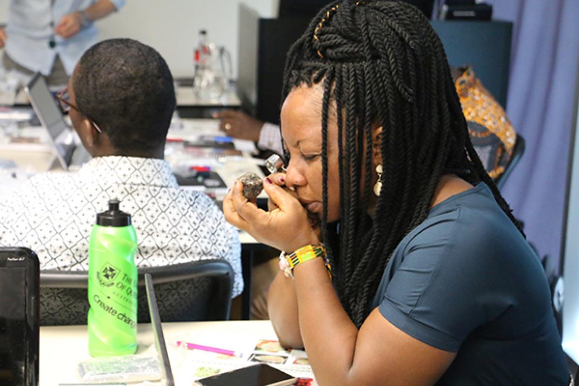 A visiting student from Africa examines a gem stone.