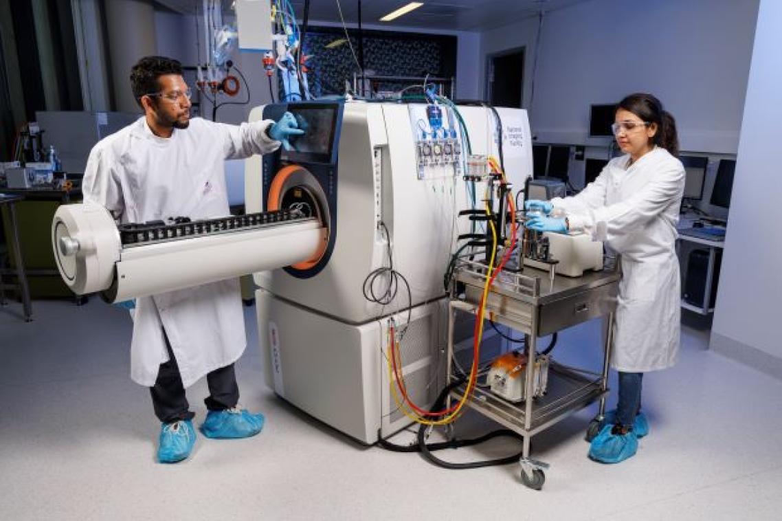 two researchers looking at a large machine