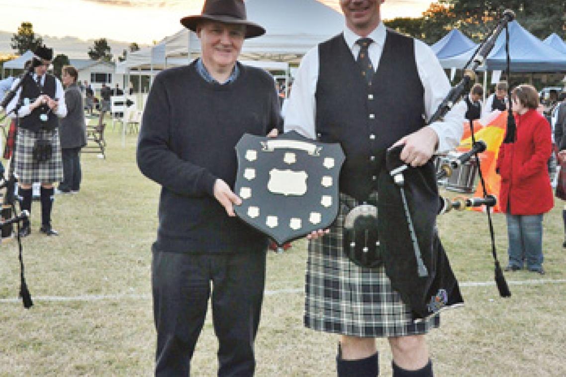 Adjunct Professor Stewart Gill and Pipe Major Andrew McCabe holding the Association Trophy that the UQ Pipe Band won at the 2012 Queensland Grade 4 Champions.