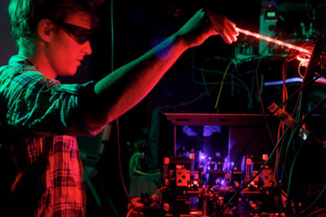 The University of Queensland's Dr Matthew Broome peering over the BosonSampling quantum computer.