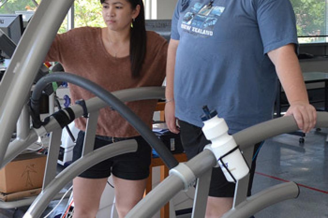 Joyce Ramos helps Karen O'Brien work the treadmill controls