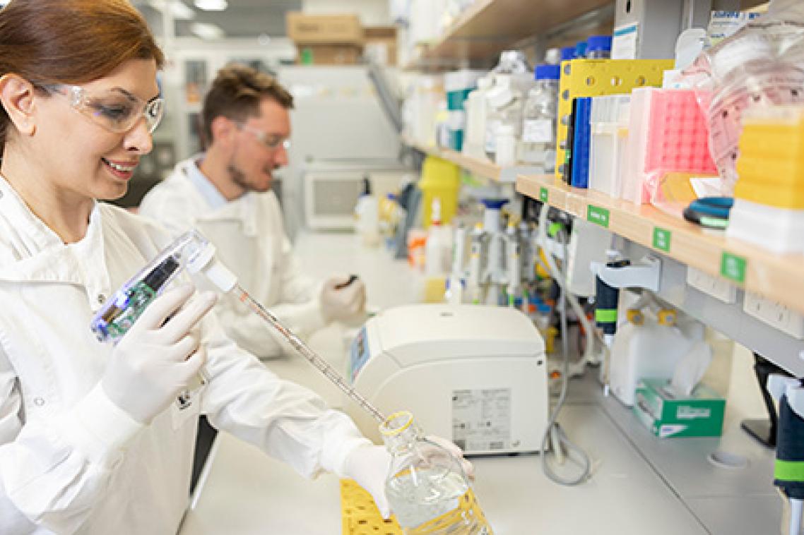 Two scientists wearing protective equipment in a science laboratory.