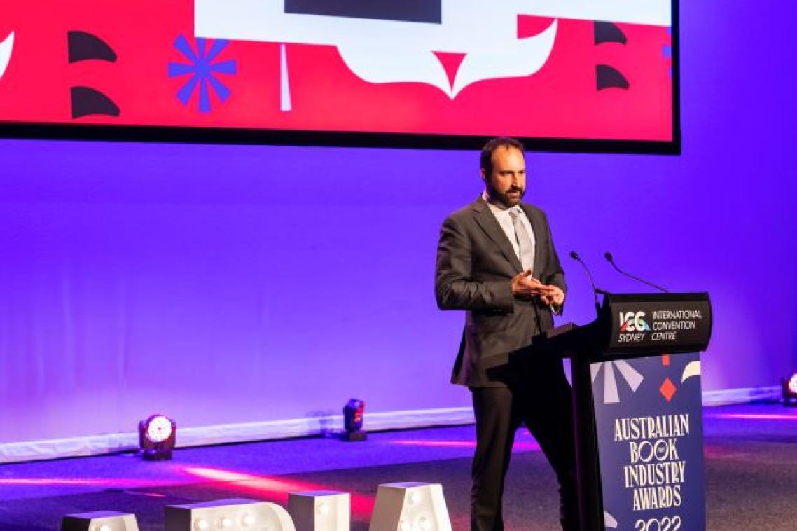 Ben James from UQP standing at a podium at the ABIA awards accepting UQP's award