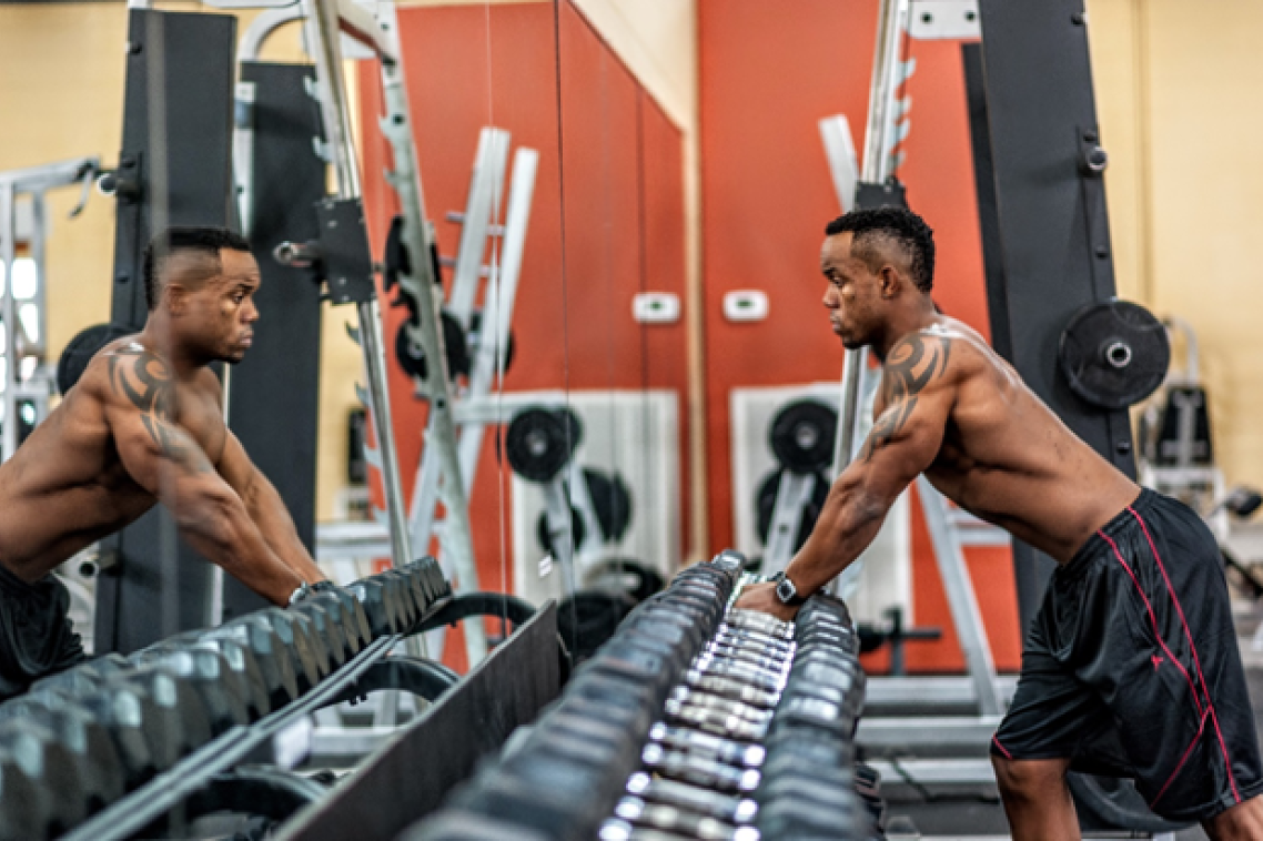 Man looking at himself in the mirror at a gym