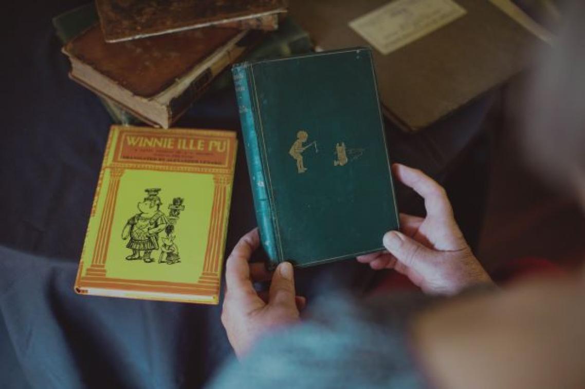 First edition Winne-the-Pooh being held with another book in background. Credit, UQ