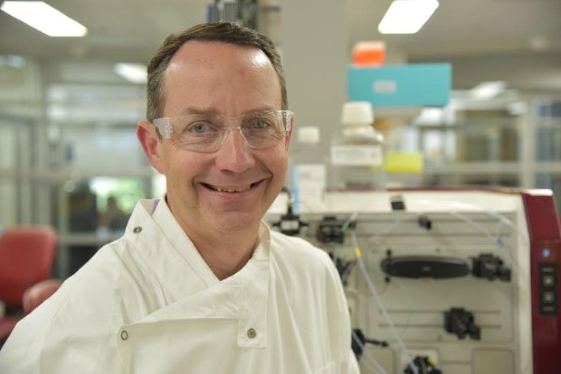 Portrait photo of UQ Professor Trent Munro wearing a white coat in a laboratory. Supplied.