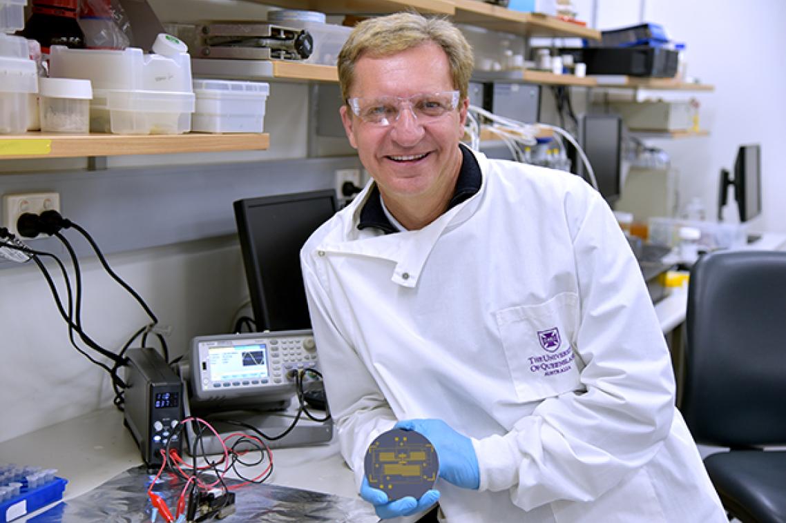 A scientist wearing a lab coat and holding a piece of equipment