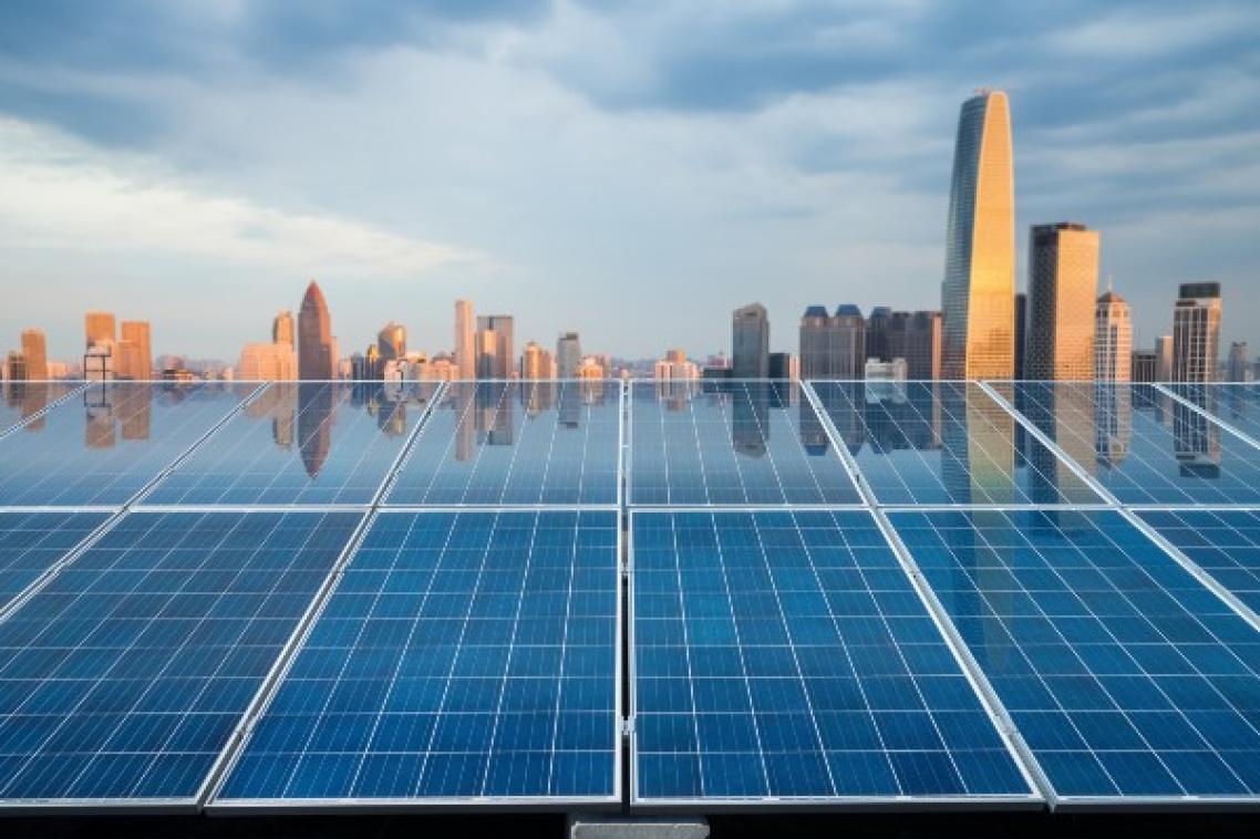 Solar panels with cityscape in the background.