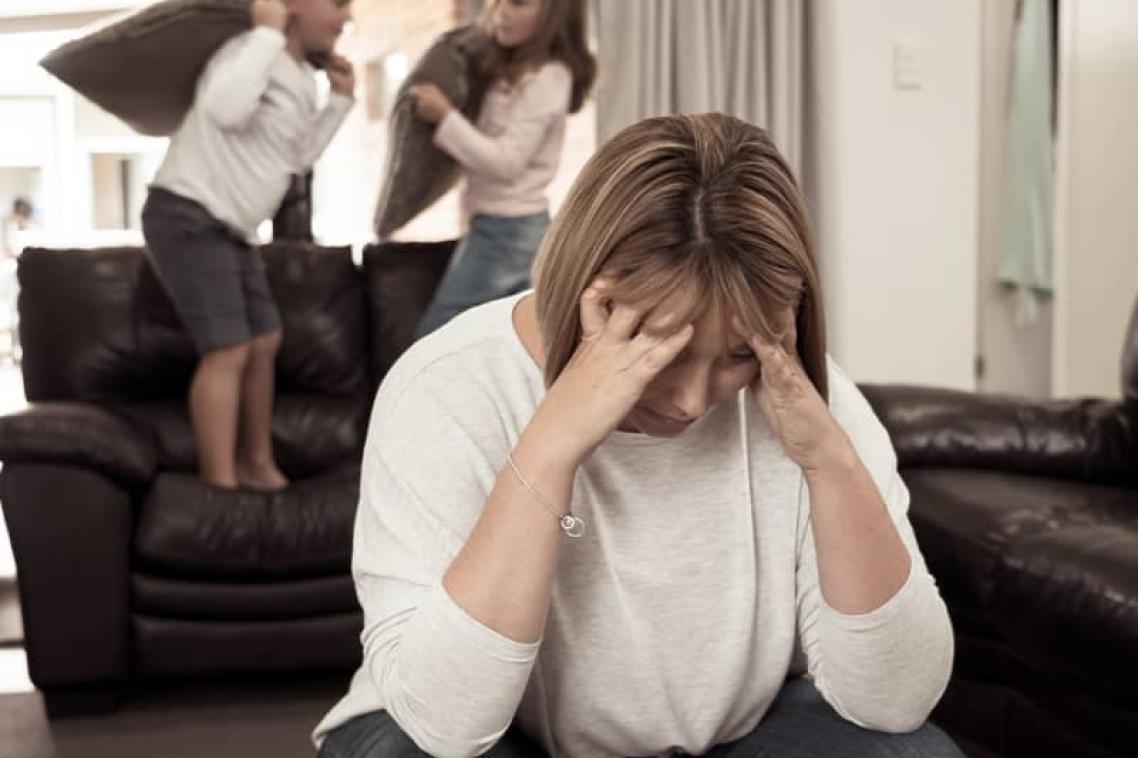 Upset parent with naughty kids in the background