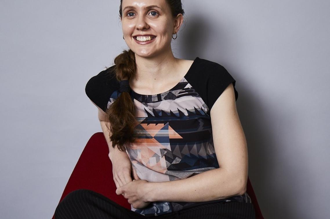 Post graduate student Alicia Kirk smiles at the camera, while sitting on a beanbag.