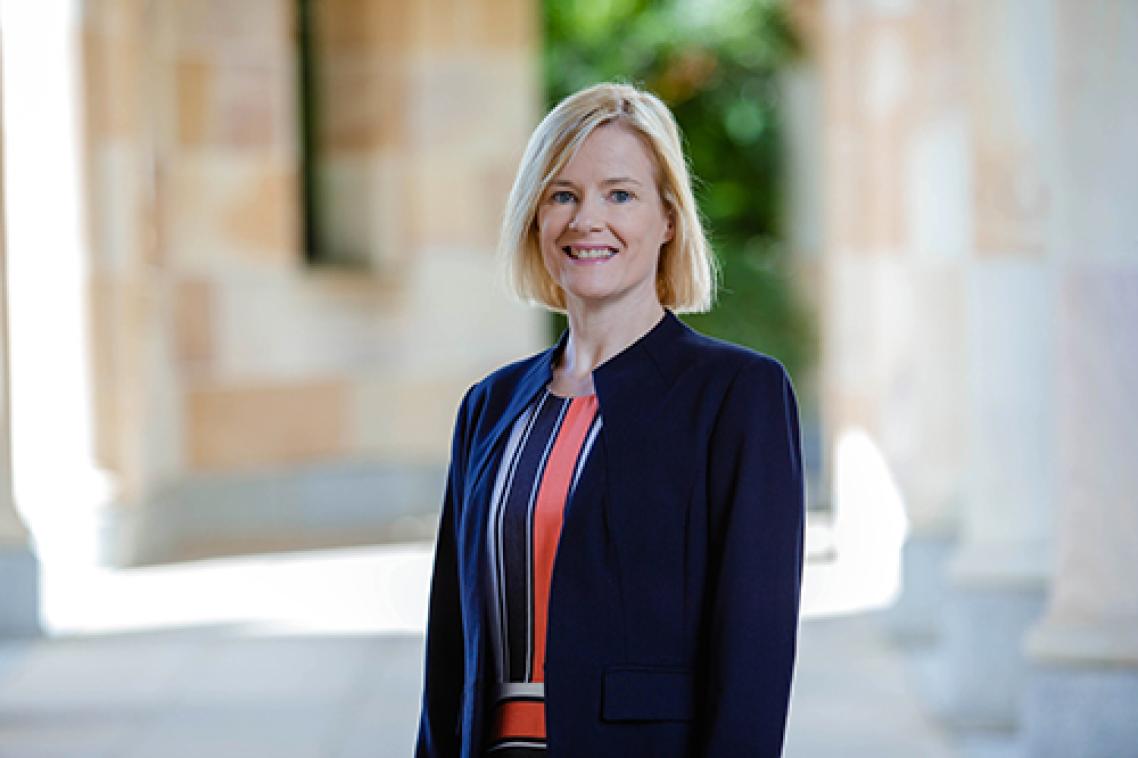 Professor Brenda Gannon from the waist up with UQ sandstone visible behind