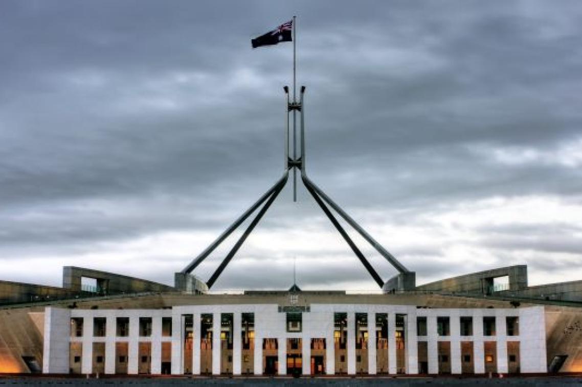 Parliament house in Canberra under a gloomy sky. Adobe.